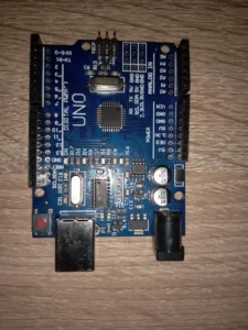 Board Arduino UNO R3 mạch xanh dương chip dán ATmega328P nhìn từ trên xuống trên mặt gỗ