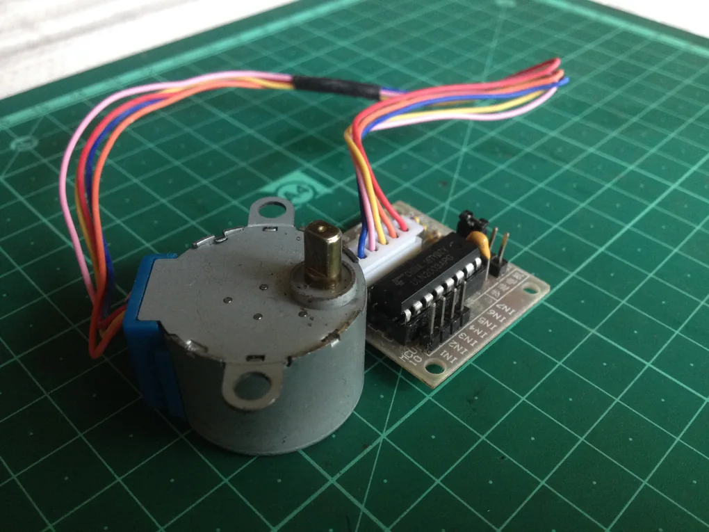 Động cơ bước 28BYJ-48 5V nối dây với bo driver ULN2003, đặt trên tấm kê cắt xanh